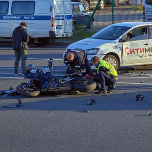 Motorcycle accident scene. Bystanders help injured rider - Colton Holm