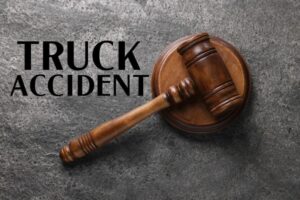 Truck accident law. Judge's gavel on grey table, top view