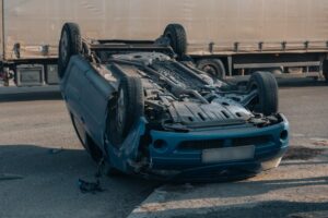 Road traffic accident. Overturned car on the highway. Severe damage to the vehicle. 