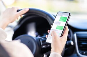 Driving car and using phone. Distracted driver texting with mobile cellphone.