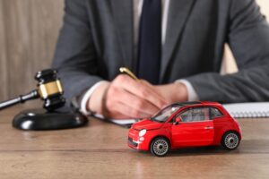 Lawyer working at wooden table indoors, focus on toy car