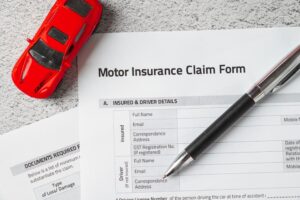 Motor or car insurance claim form with ballpoint pen and car model