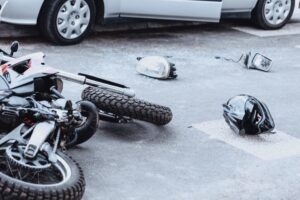 A motorcycle and helmet lying on road after collision with a car