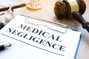 Clipboard with documents about medical negligence on a table.
